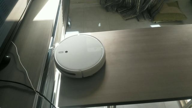 Робот-пылесос Хсиаоми убирает пыль со стола. Xiaomi robot vacuum cleaner cleans a table. смотреть онлайн