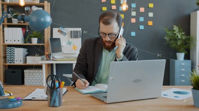 Serious guy in glasses office worker peaking on mobile phone working at desk in workplace смотреть онлайн