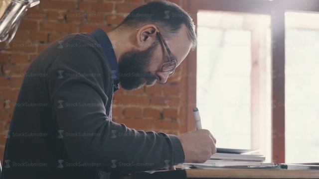 Profile Of A Man Sitting At A Table In An Office. Designer-architect