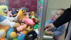 Изабелла достает игрушки из автомата с игрушками