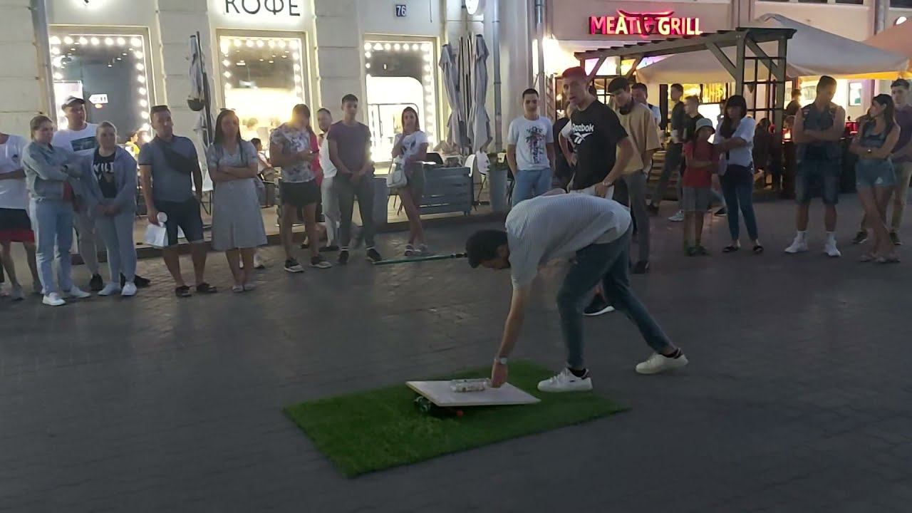 Толпа пытается поднять бутылку удочкой