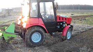 Трактор Беларус 320 (МТЗ) с почвенной фрезой в процессе работы