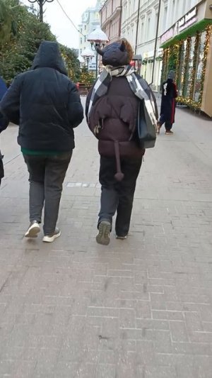 Девушка в куртке с рожками, крылышками и хвостиком.