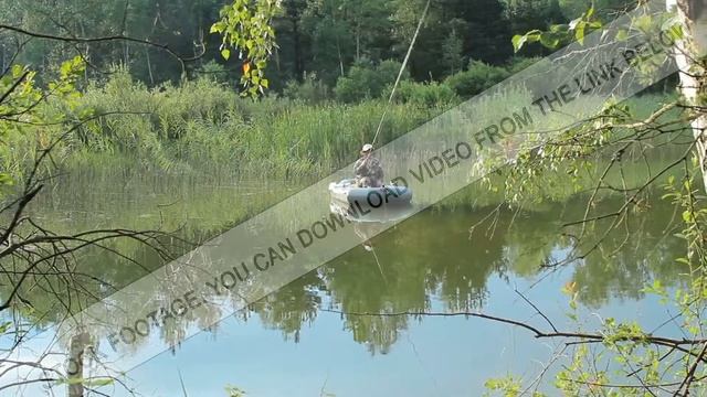 The fisherman floats on the river in an inflatable boat. Moving camera by slider. Activities in the