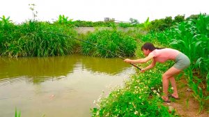 Рыбалка Красивая девушка охотится и ловит крупную рыбу в заросшем водоеме Классная рыбалка