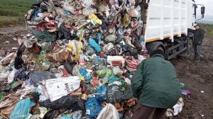 Мусоровоз на свалке в болоте