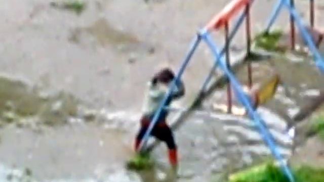 Мальчик купается в луже