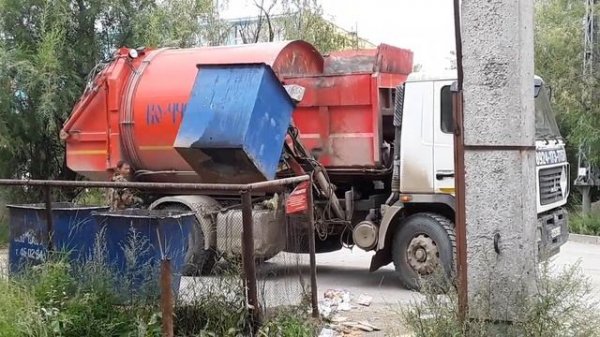 Мусоровоз поднимает мусорный бак