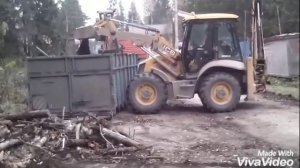 Трактор JCB убирает мусор.