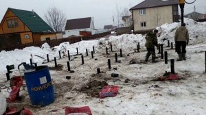 Как вкручивают железные сваи зимой.