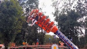 Взрослые визжат от восторга на аттракционе Бумеранг