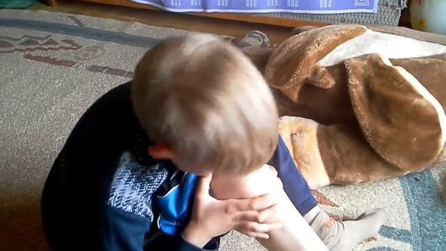 Деревенский мальчик гавкает  на  коленку.