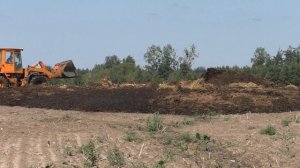 АМКОДОР сгребает навоз в кучу