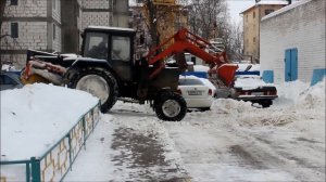 Трактор убирает снег во дворе Нижнего Новгорода