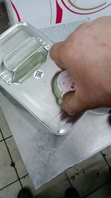 открываем металлическую пробку на металлической канистре с маслом.