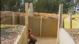 Строит дом в джунглях, ручным инструментом.