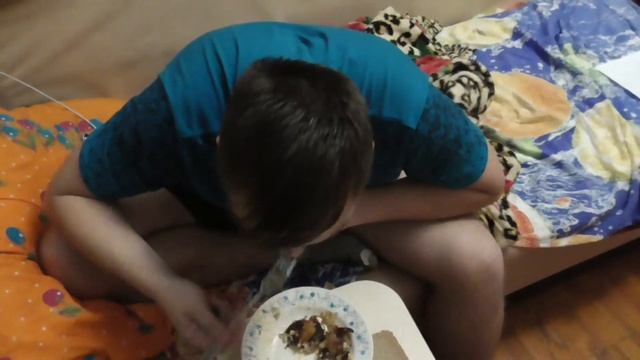 Брат ест картошку с мясом и слушает музыку