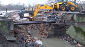 Экскаватор-погрузчик JCB Super работает телескопом на чистке дна ручья