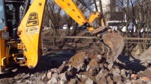 Экскаватор JCB легко снимает брусчатку ковшом с зубьями