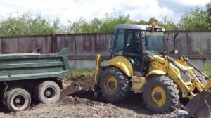 Экскаватор-погрузчик New Holland LB115  грузит самосвал КАМАЗ.