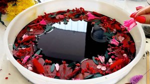 Стол черный из эпоксидной смолы с красными цветами.