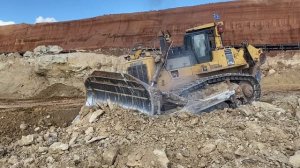 Огромный бульдозер Komatsu D475 рыхлит твердый камень.
