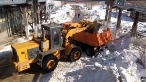 Фронтальный погрузчик В-138 грузит Камаз снегом
