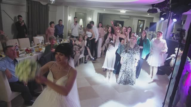 Девушка очень счастлива, что поймала букет невесты