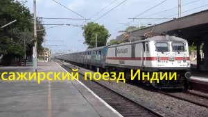 Пассажирский поезд с синими вагонами в Индии пролетает пустой перрон