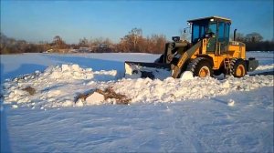 Фронтальный погрузчик пробивает дорогу