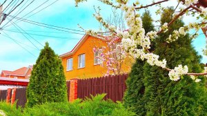 Красивый двухэтажный домик с плодовыми деревьями на участке