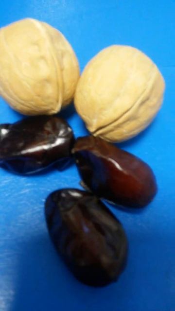 Три финика и два ореха на синей поверхности двадцать четвёртого марта