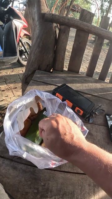 Уличная еда в Индонезии. Вареный рис с острым кальмаром в банановом листе. Seafood