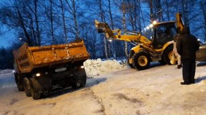 Трактор грузит снег
