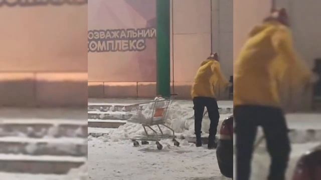 Как в Кривом Роге работник возле детского центра снег убирал