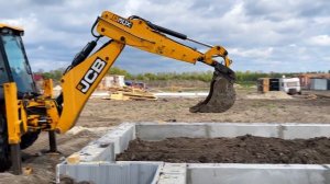 Excavator JCB 3CX Eco and Tractor John Deere digging the sand