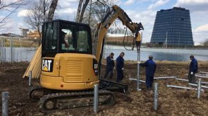 Мини экскаватор закручивает винтовые сваи в Сколково