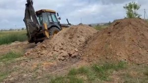 Трактор John Deere толкает грунт. John Deere tractor pushes the ground.