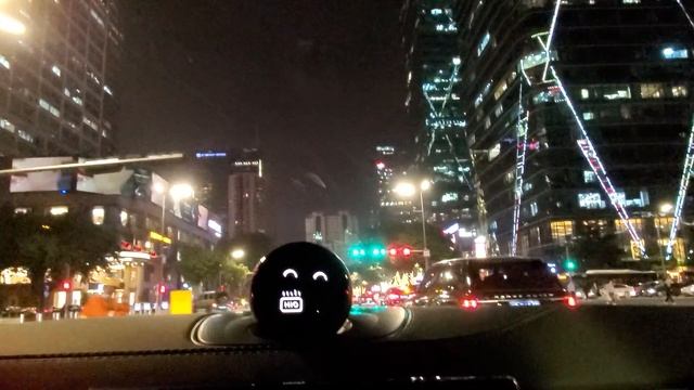 NIO car following a white Tesla model 3 at night in city's downtown смотреть онлайн
