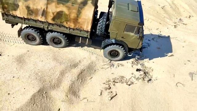 Модель бортового КАМАЗа с тентом едет по песку смотреть онлайн