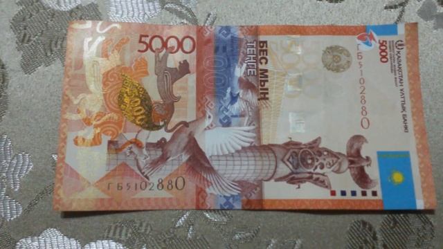 БАНКНОТА 5000 ТЕНГЕ № серии ГБ5102880 на парчовой поверхности 27-ого Января - ДЕНЕЖНЫЙ ПОТОК