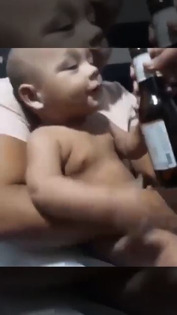 Маленький ребенок радуется бутылке пива