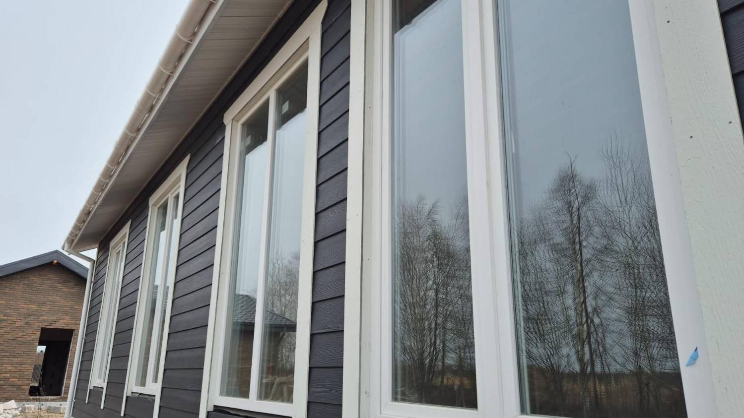 Каркасный дом площадью 98 кв.м. Фасад дома - фиброцементный сайдинг. Крыша кликфальц.