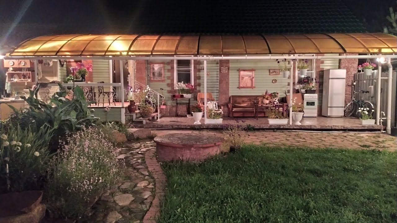 Терраса с крышей из поликарбоната в ночное время.