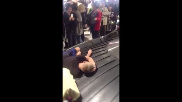Шокирующее видео - парень уснул на ленте выдаче багажа в аэропорту и катался спал смотреть онлайн