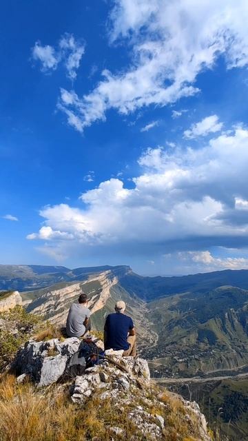 На краю обрыва, в горах.