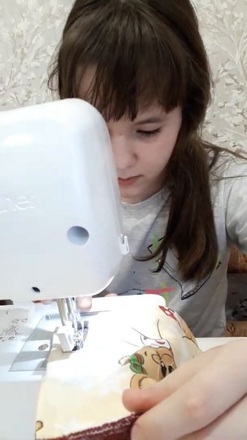 Полинка учится шить.