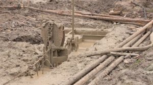 Эпизод выемки грунта из траншеи грейфером.