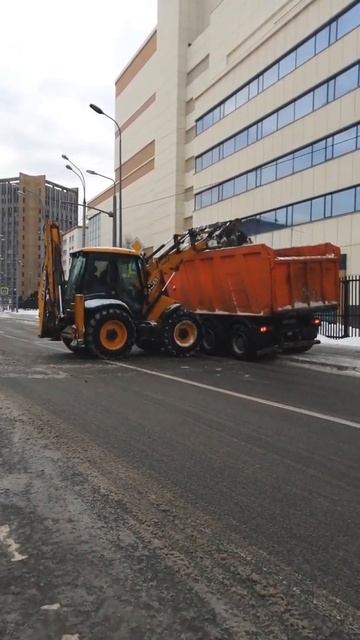 Трактор загружает снег в грузовик-самосвал. смотреть онлайн