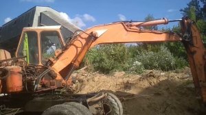 экскаватор атлас выковыривать металл и грузит на кама